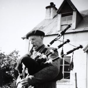 Johnny with his pipes outside Kyltra cottage